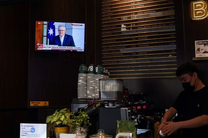 &copy; Reuters. تلفزيون في مقهى يبث حديث رئيس الوزراء الأسترالي سكوت موريسون عن مهمة الإنقاذ العسكري في كابول في سيدني يوم 18 أغسطس آب 2021. تصوير: لورين إيليوت