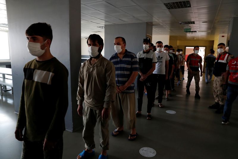 © Reuters. مهاجرون معظمهم من أفغانستان ينتظرون الغداء في مركز إعادة ترحيل في فان التركية يوم الأحد. تصوير: مراد سيزر - رويترز