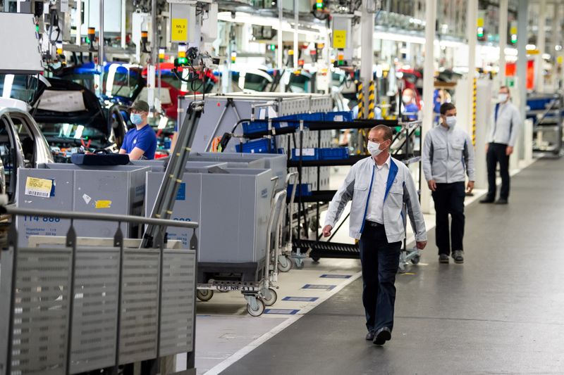 &copy; Reuters. FILE PHOTO: Staff wear protective masks at the Volkswagen assembly line in Wolfsburg, Germany, April 27, 2020. Swen Pfoertner/Pool via REUTERS