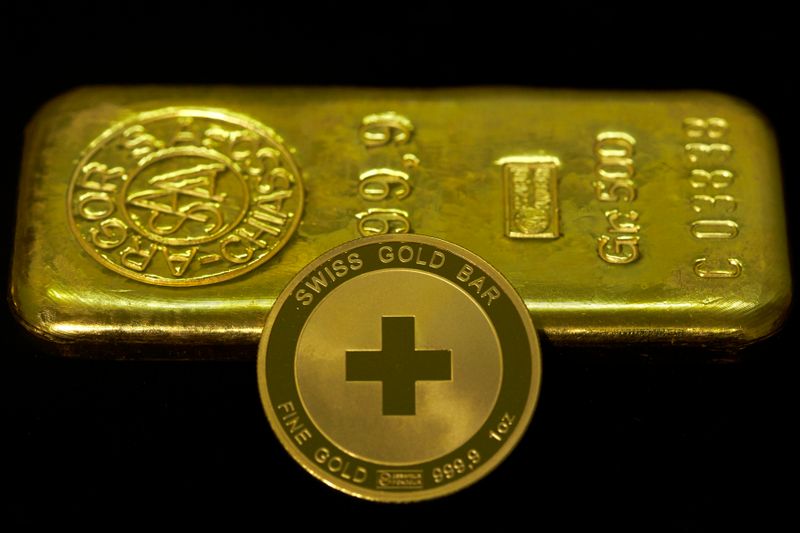 &copy; Reuters. An ounce of gold coin is pictured in front of a 500g ingot at Jolliet numismatic shop in Geneva November 19, 2014. Support among Swiss voters for a referendum proposal that would force a huge increase in the central bank's gold reserves has slipped to 38 