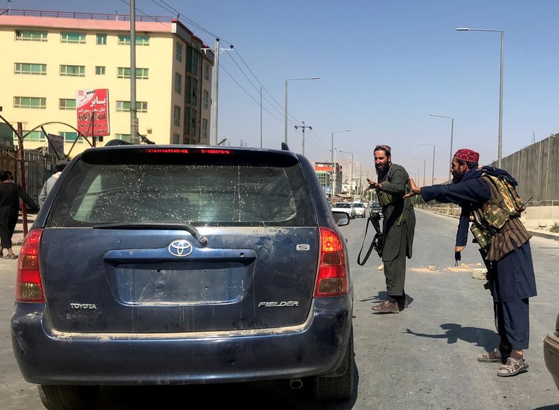 &copy; Reuters. FOTO DE ARCHIVO: Miembros de las fuerzas talibanes hacen un gesto mientras revisan un vehículo en una calle de Kabul, Afganistán, el 16 de agosto de 2021. REUTERS/Stringer
