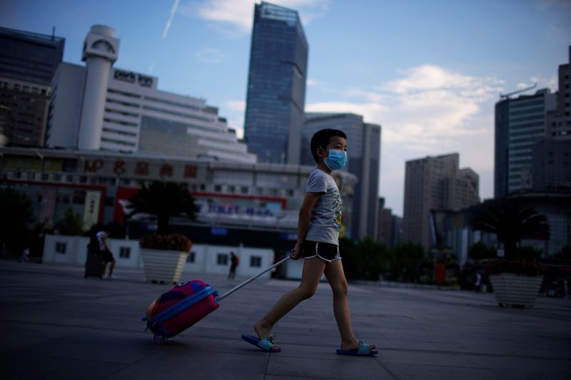 &copy; Reuters. Menino de máscara protetora caminha perto da Estação Ferroviária de Xangai, cidade que registrou novos casos de coronavírus, China, 23 de agosto de 2021. REUTERS/Aly Song