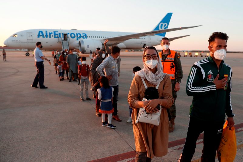 © Reuters. مجموعة من الأفغان يصلون إلى قاعدة توريخون الجوية في توريخون دي أردوز  على مشارف مدريد يوم 20 أغسطس اب 2021. صورة لرويترز من ممثل لوكالات الأنباء.