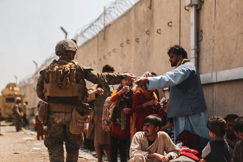 © Reuters. FILE PHOTO: A U.S. Marine passes out water to evacuees during an evacuation at Hamid Karzai International Airport, Kabul, Afghanistan, August 22, 2021. U.S. Marine Corps/Sgt. Isaiah Campbell/Handout via REUTERS