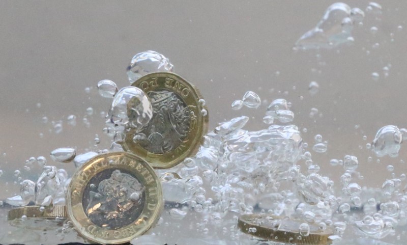&copy; Reuters. FILE PHOTO: UK pound coins plunge into water in this illustration picture, October 26, 2017. REUTERS/Dado Ruvic/Illustration