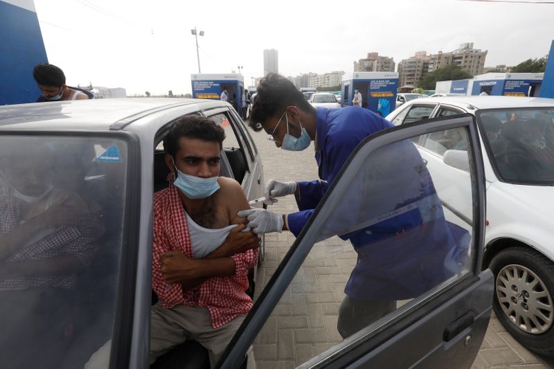 &copy; Reuters. FILE PHOTO: A resident receives a dose of coronavirus disease (COVID-19) vaccine at a drive-through vaccination facility in Karachi, Pakistan August 3, 2021. REUTERS/Akhtar Soomro