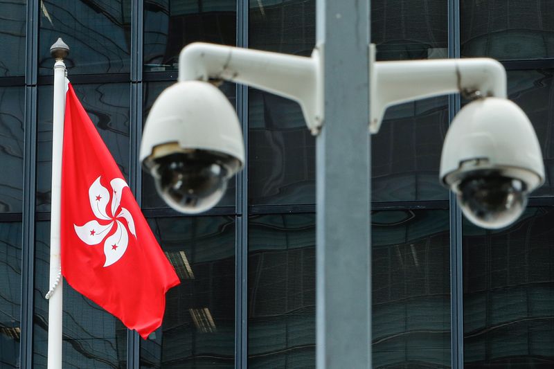 &copy; Reuters. 香港政府は２４日、「国家の安全を守る」ためとして、新たな映画検閲法を導入すると発表した。写真は監視カメラと香港旗。７月２０日、香港で撮影（２０２１年　ロイター/Tyrone Siu）