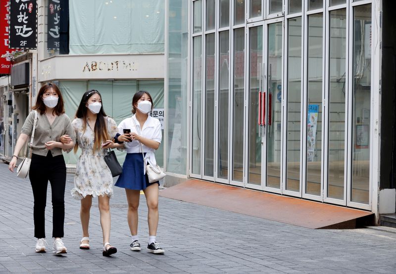 &copy; Reuters. FILE PHOTO: Women wearing masks walk in a shopping district amid the coronavirus disease (COVID-19) pandemic in Seoul, South Korea, July 9, 2021. REUTERS/ Heo Ran