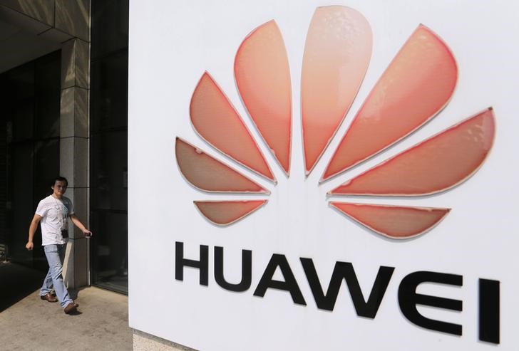 &copy; Reuters. A man walks past a Huawei company logo outside the entrance of a Huawei office in Wuhan, Hubei province October 9, 2012. The U.S. ambitions of two Chinese telecom equipment makers were stopped in their tracks on Monday as a congressional report urged Amer