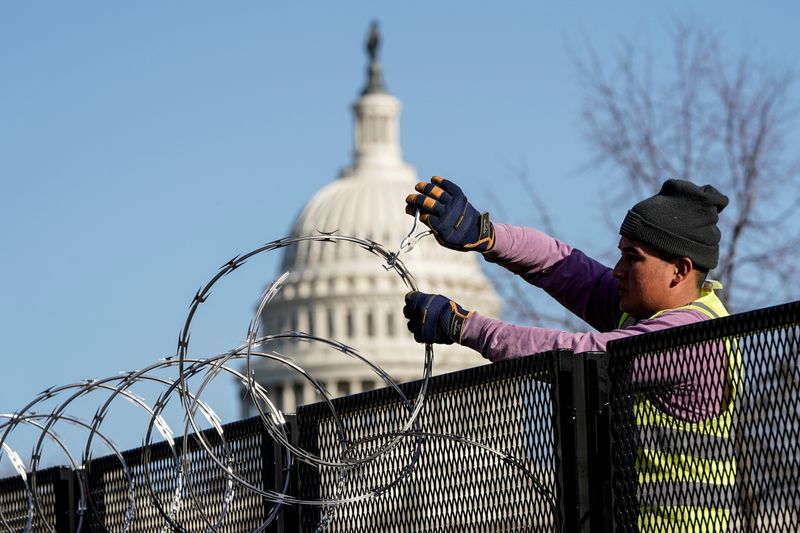 &copy; Reuters. FILE PHOTO: A worker removes razor wire from the top of security fencing as part of a reduction in heightened security measures taken after the January 6th attack on the U.S. Capitol in Washington, U.S., March 20, 2021.  REUTERS/Joshua Roberts