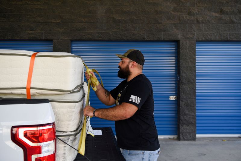 &copy; Reuters. U.S. military veteran Luis Gonzales secures mattresses on a truck while gathering supplies for Afghan refugees who are being resettled after their evacuation from Afghanistan in Houston, Texas, U.S., August 25, 2021.  REUTERS/Callaghan O'Hare