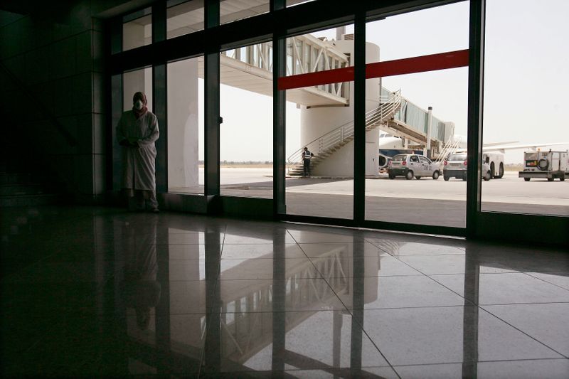 &copy; Reuters. موظف يتبع الاجراءات الاحترازية في مطار هواري بومدين بالجزائر العاصمة. رويترز