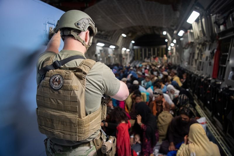 &copy; Reuters. جندي أمريكي يتفقد مجموعة من الأفغان داخل طائرة إجلاء من كابول يوم 24 أغسطس آب 2021. صورة حصلت عليها رويترز من طرف ثالث