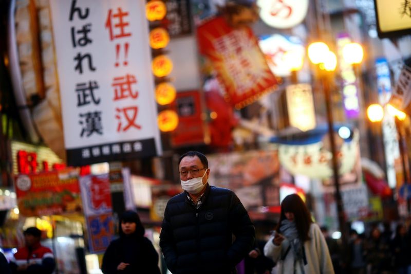 &copy; Reuters. A man, wearing protective mask following an outbreak of the coronavirus disease (COVID-19), walks on an almost empty street in the Dotonbori entertainment district of Osaka, Japan, March 14, 2020. Pictured taken March 14, 2020. REUTERS/Edgard Garrido