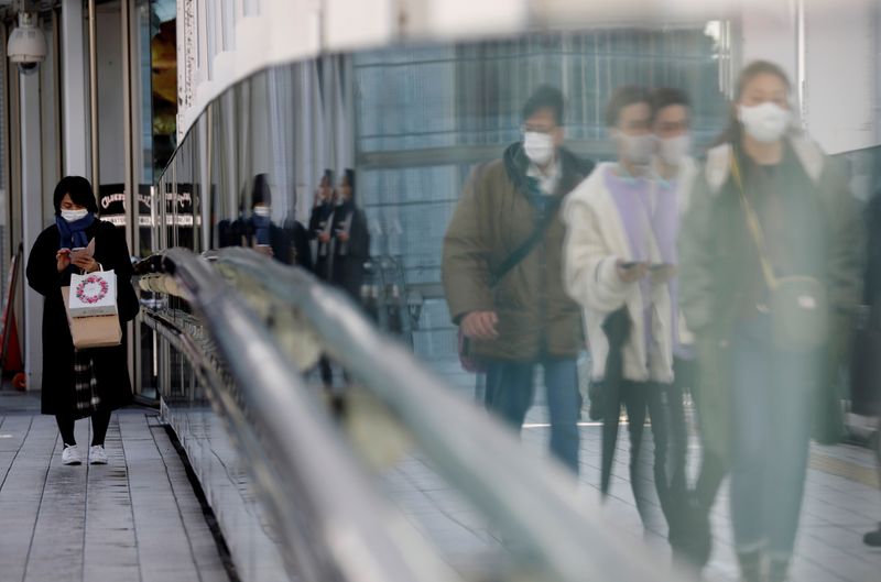 &copy; Reuters. FILE PHOTO: Pedestrians wearing protective masks amid the coronavirus disease (COVID-19) outbreak, walk on a street in Tokyo, Japan, February 2, 2021. REUTERS/Kim Kyung-Hoon