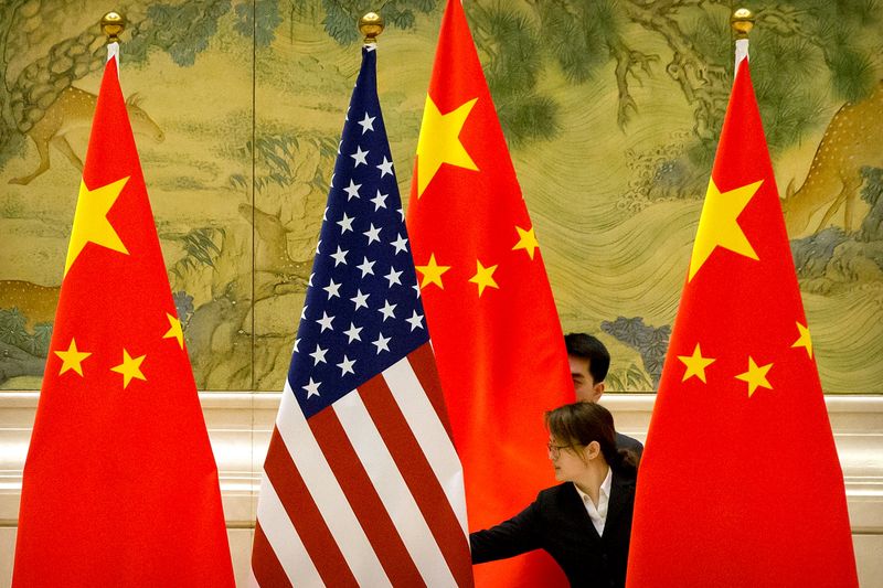 &copy; Reuters. FILE PHOTO: Chinese staffers adjust U.S. and Chinese flags before the opening session of Sino-U.S. trade negotiations in Beijing, Feb. 14, 2019. Mark Schiefelbein/Pool via REUTERS