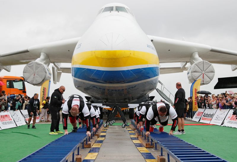 &copy; Reuters. Hombres fuertes ucranianos intentan marcar un récord mundial por tirar del avión de carga más grande del mundo, un Antonov An-225 Mriya, en el aeropuerto de la localidad de Hostomel, a las afueras de Kiev, Ucrania. 26 de agosto, 2021. REUTERS/Gleb Gara