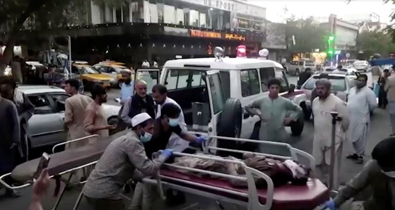 © Reuters. A screen grab shows people carrying an injured person to a hospital after an attack at Kabul airport, in Kabul, Afghanistan August 26, 2021. REUTERS TV/1TV/Handout via REUTERS 