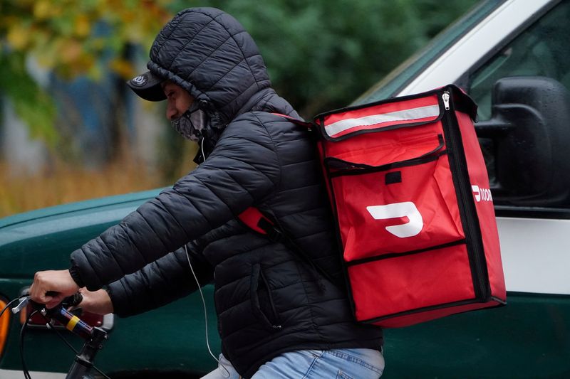&copy; Reuters. FILE PHOTO: A delivery person for Doordash rides his bike in the rain during the coronavirus disease (COVID-19) pandemic in the Manhattan borough of New York City, New York, U.S., November 13, 2020. REUTERS/Carlo Allegri/File Photo