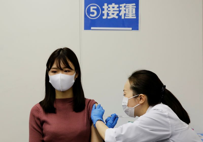© Reuters. Una empleada de la aerolínea All Nippon Airways (ANA) recibe una dosis de la vacuna de Moderna contra el coronavirus en las instalaciones de la compañía en el aeropuerto de Haneda, Tokio, Japón. 14 junio 2021. REUTERS/Kim Kyung-Hoon
