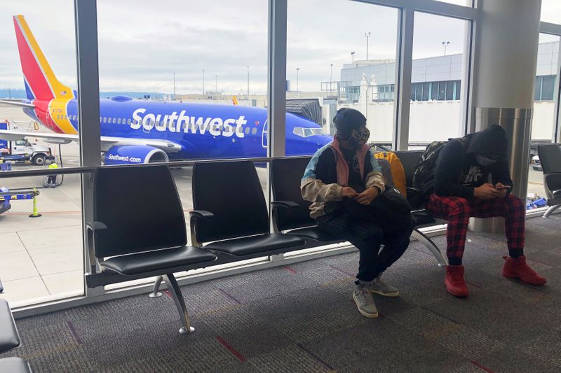 © Reuters. FILE PHOTO: Air travelers wear face masks waiting to board a Southwest Airlines flight as the spread of coronavirus disease (COVID-19) continues, at Oakland International airport in Oakland, California, U.S., April 9, 2020. REUTERS/Shannon Stapleton