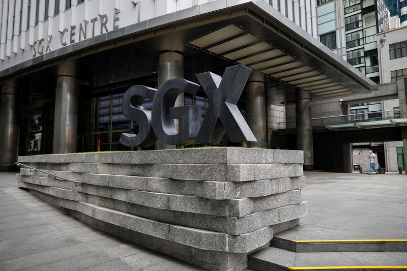 © Reuters. FILE PHOTO: A man wearing a protective face mask walks past the Singapore Exchange (SGX) which stays open during 