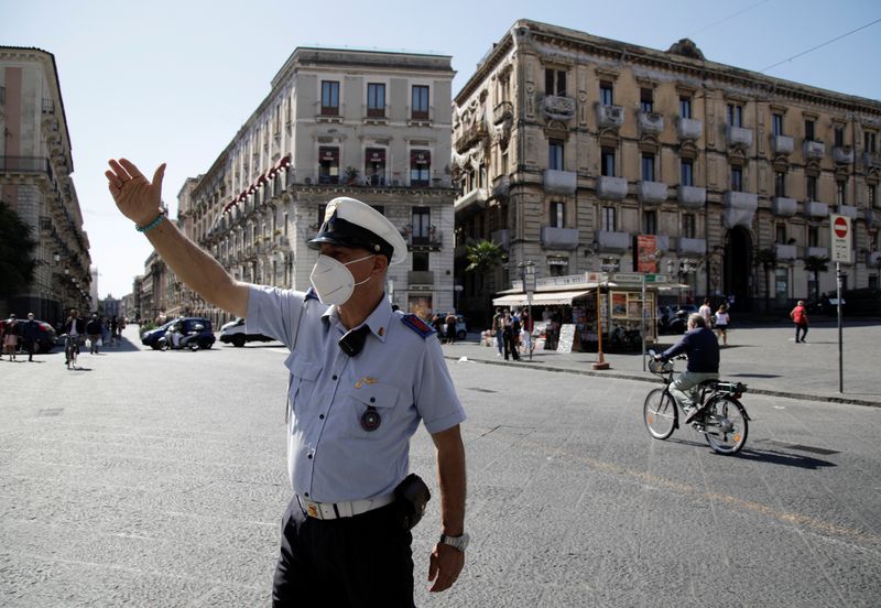 &copy; Reuters. Un poliziotto con una maschera a Catania, in Sicilia. REUTERS/Antonio Parrinello