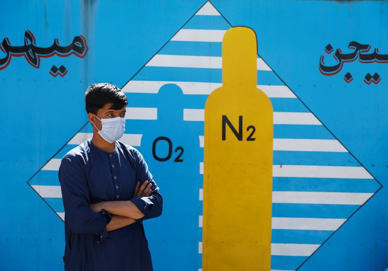 &copy; Reuters. FOTO DE ARCHIVO: Un hombre espera fuera de una fábrica para que le rellenen la bombona de oxígeno en Kabul, Afganistán, el 15 de junio de 2021. REUTERS/Stringer