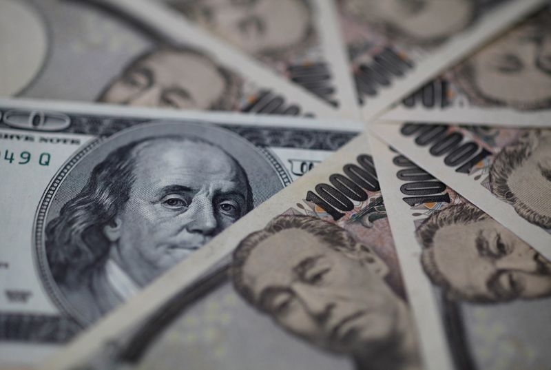 © Reuters. Una banconota da cento dollari e 10.000 yen giapponesi, Tokyo, il 28 febbraio 2013. REUTERS / Shohei Miyano 