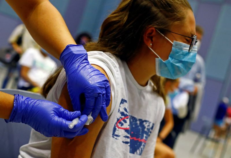 &copy; Reuters. FILE PHOTO: A nurse administers the first dose of the Moderna vaccine against coronavirus disease (COVID-19) to 15-year-old Tatiana Suarez at a vaccination centre in Meloneras on the island of Gran Canaria, Spain, July 28, 2021. REUTERS/Borja Suarez