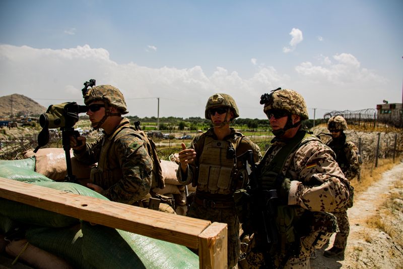 &copy; Reuters. 　アフガニスタンからの米軍撤退が最終段階に入った。西側の安全保障当局者が２９日、ロイターに明らかにした。写真は２８日、カブール空港で監視にあたる兵士ら（２０２１年　ロイタ