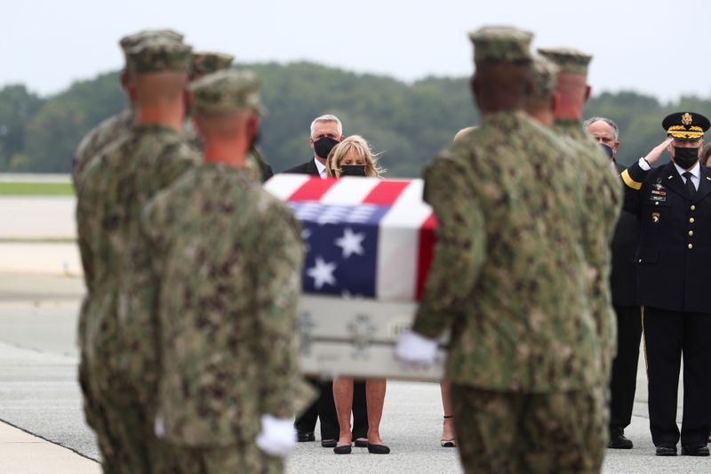 © Reuters. بايدن وزوجته خلال مراسم استقبال جثامين جنود أمريكيين قتلوا في كابول بقاعدة دوفر الجوية في ولاية ديلاوير الأمريكية يوم الاحد. تصوير: توم برينر - رويترز. 