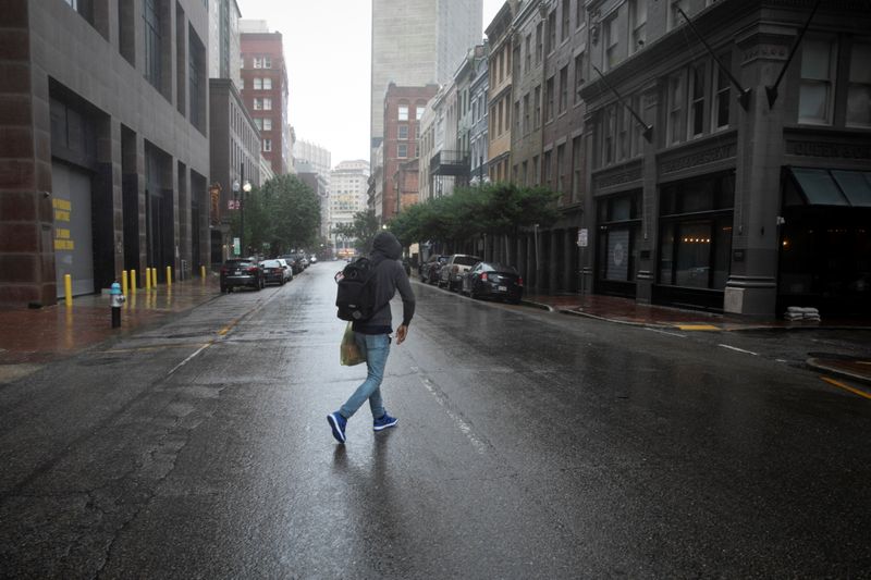 © Reuters. رجل يسير فيما تهطل الأمطار مع وصول الإعصار إيدا إلى نيو أورليانز يوم الأحد. تصوير: ماركو بيلو - رويترز