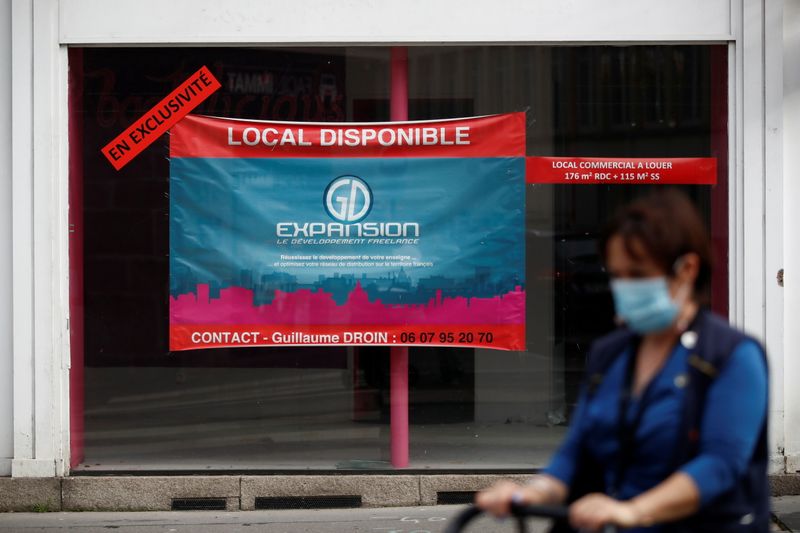 &copy; Reuters. A woman, wearing a protective face mask, walks past a commercial space for rent in a street in Nantes, France, November 10, 2020.  REUTERS/Stephane Mahe