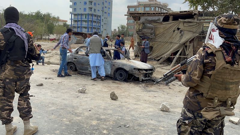 &copy; Reuters. Dei cittadini afghani fanno una foto del veicolo da cui sono stati lanciati i razzi a Kabul, Afghanistan, 30 agosto 2021 REUTER/Stringer