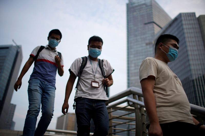 &copy; Reuters. Men wearing protective masks walk on a bridge, following new cases of the coronavirus disease (COVID-19), in Shanghai, China August 23, 2021. REUTERS/Aly Song
