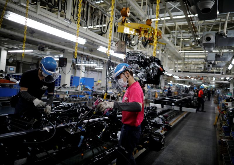 &copy; Reuters. Employees wearing protective face masks and face guards work on the automobile assembly line as the maker ramps up car production with new security and health measures as a step to resume full operations, during the outbreak of the coronavirus disease (CO