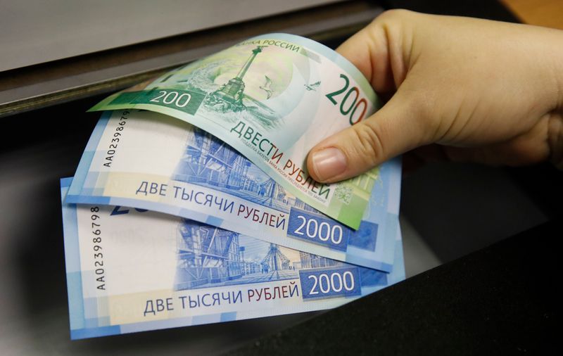 © Reuters. A woman holds new 200 and 2,000 rouble banknotes in a bank in Moscow, Russia November 21, 2017. REUTERS/Maxim Shemetov