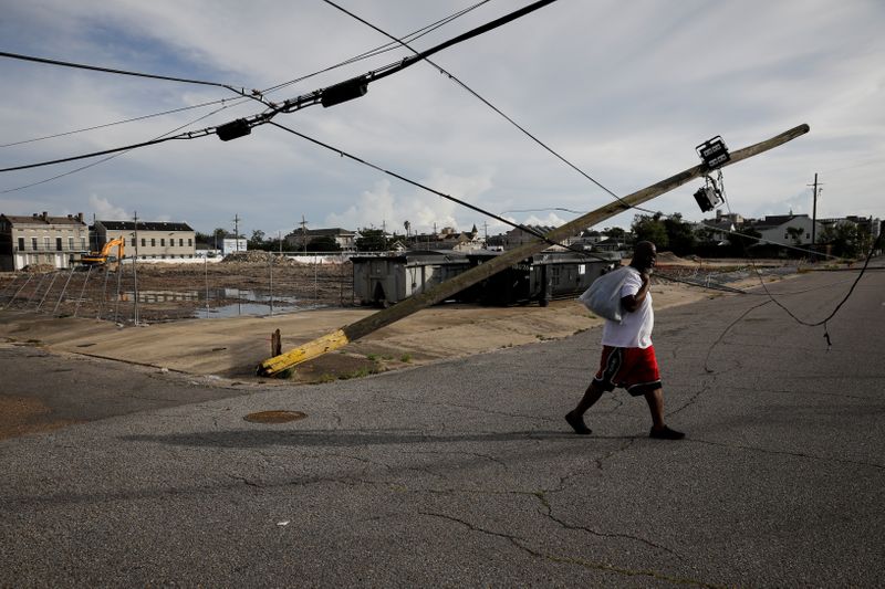 &copy; Reuters. Homem passa ao lado de linha de transmissão de eletricidade danificada pela passagem do furacão Ida em Nova Orleans
30/08/2021 REUTERS/Marco Bello