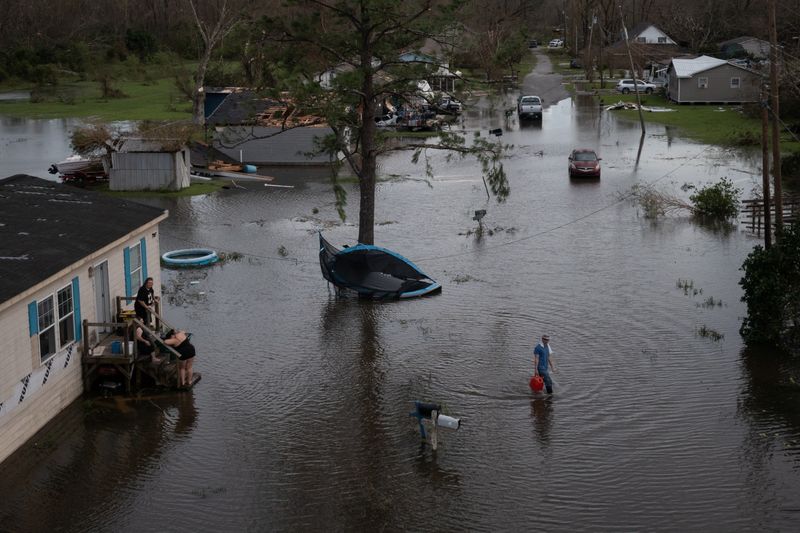 &copy; Reuters. رجل يسير عائدا إلى منزله بعد إعصار إيدا في ولاية لويزيانا الأمريكية يوم 30 أغسطس آب 2021. صورة لرويترز.