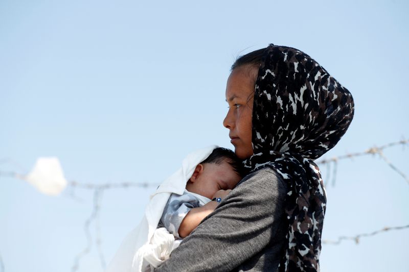 &copy; Reuters. FILE PHOTO: An Afghan woman and her month-old son are seen outside the new temporary camp for migrants and refugees, on the island of Lesbos, Greece, September 21, 2020. REUTERS/Yara Nardi