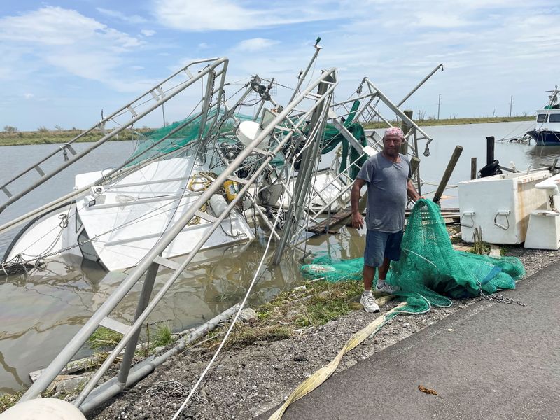 &copy; Reuters. Shrimpers survey the damage to homes and shrimp boats after Hurricane Ida  made landfall in Golden Meadow, Louisiana, U.S., August 31, 2021. REUTERS/Devika Krishna Kumar