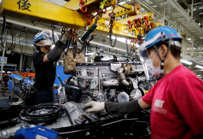 &copy; Reuters. Employees wearing protective face masks and face guards work on the automobile assembly line as the maker ramps up car production with new security and health measures as a step to resume full operations, during the outbreak of the coronavirus disease (CO