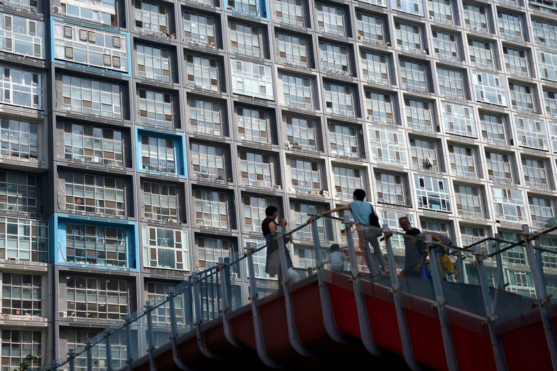 &copy; Reuters. FILE PHOTO: People wearing face masks are seen on an overpass in front of a residential building in Beijing, China August 11, 2020. Picture taken August 11, 2020. REUTERS/Tingshu Wang