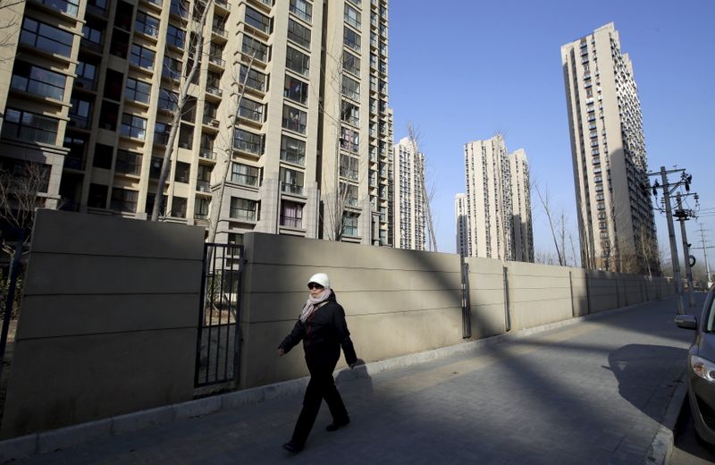 &copy; Reuters. FILE PHOTO: A woman walks past a residential compound in Beijing's Tongzhou district, China, February 25, 2016. REUTERS/Jason Lee