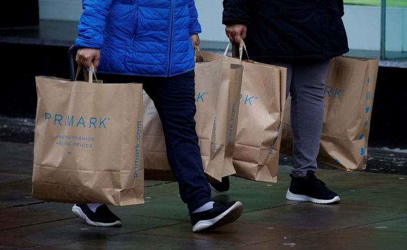 &copy; Reuters. FILE PHOTO: Shoppers carry bags from Primark at the start of the Boxing Day sales amid the outbreak of the coronavirus disease (COVID-19) in Manchester, Britain, December 26, 2020. REUTERS/Phil Noble/File Photo