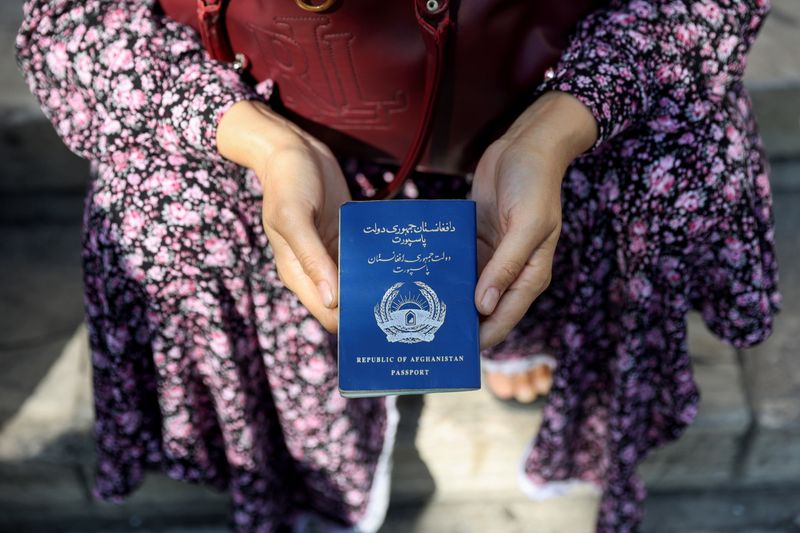 &copy; Reuters. Una rifugiata afghana tiene in mano il passaporto davanti all'ambasciata tedesca, a Teheran, Iran, 1 settembre 2021. Majid Asgaripour / WANA (West Asia News Agency) tramite REUTERS  
