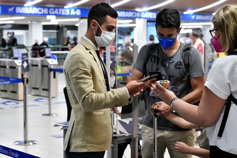 &copy; Reuters. أشخاص يعرضون تصاريح المرور الصحية الخاصة بهم في مطار بميلانو يوم الأربعاء. تصوير: فلافيو لو سكالزو - رويترز
