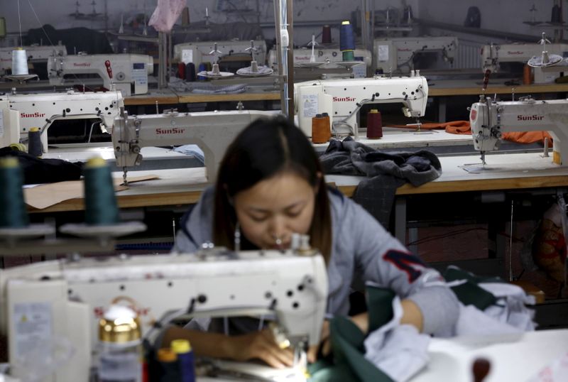 &copy; Reuters. FILE PHOTO: A woman works in a small-sized factory producing clothes and hats, in which more than half of its production line has stopped its operation because of a downturn in its business at the Qingyundian industrial zone in Beijing, China, October 19,