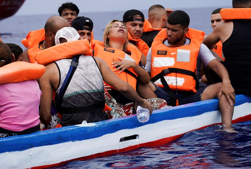 &copy; Reuters. Una mujer embarazada junto a varios migrantes que esperan en una embarcación de madera a ser rescadatos por la Guardia Costiera italiana cerca de la costa de Lampedusa, en el mar Mediterráneo, el 1 de septiembre de 2021. REUTERS/Juan Medina